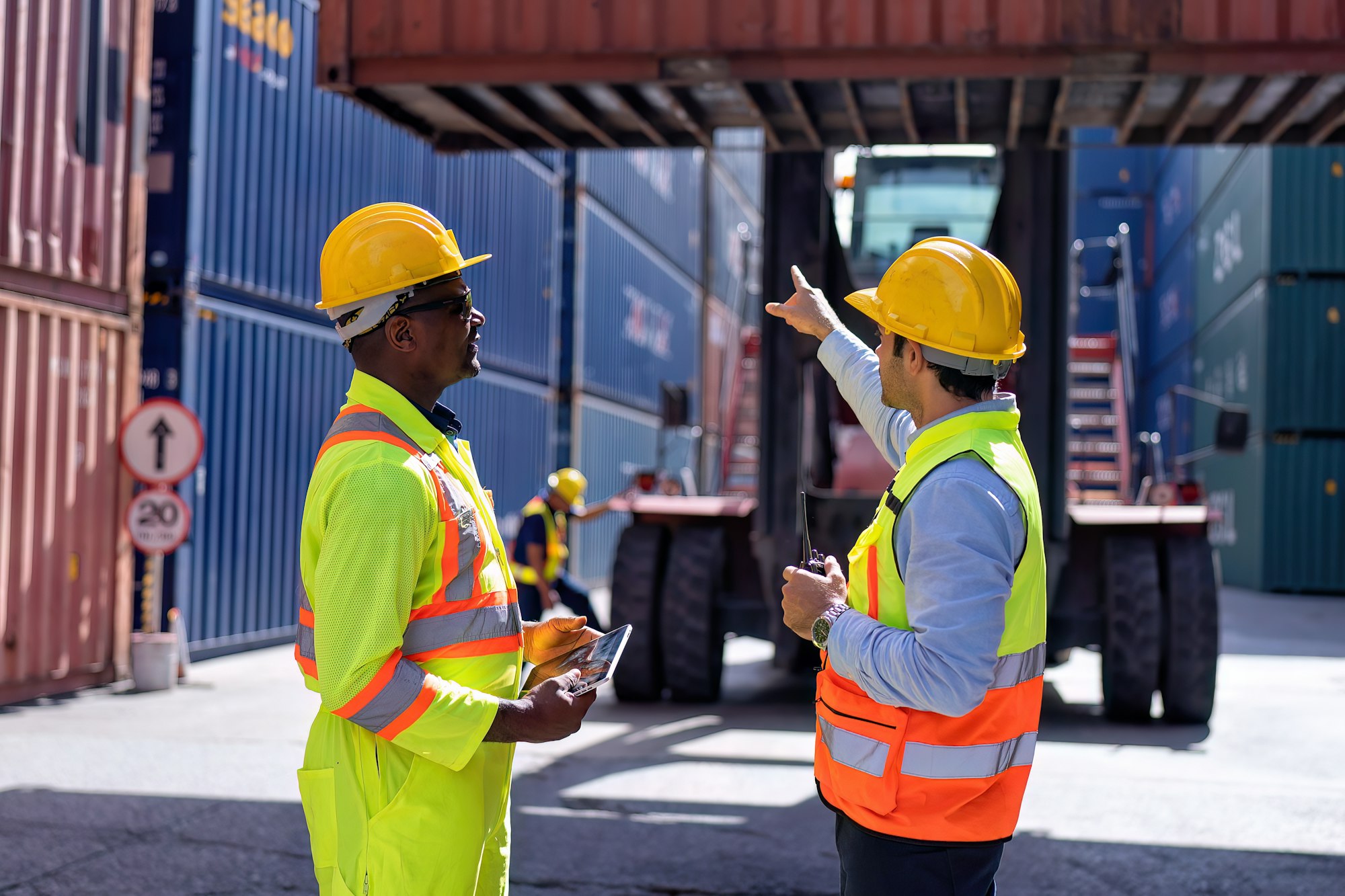 Engineer working in container storage yard stand front of container lift truck ready to delivery